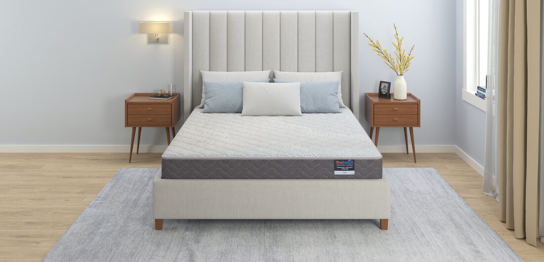 A finished Beloit custom mattress made up on a bed in a calm, sunlit bedroom